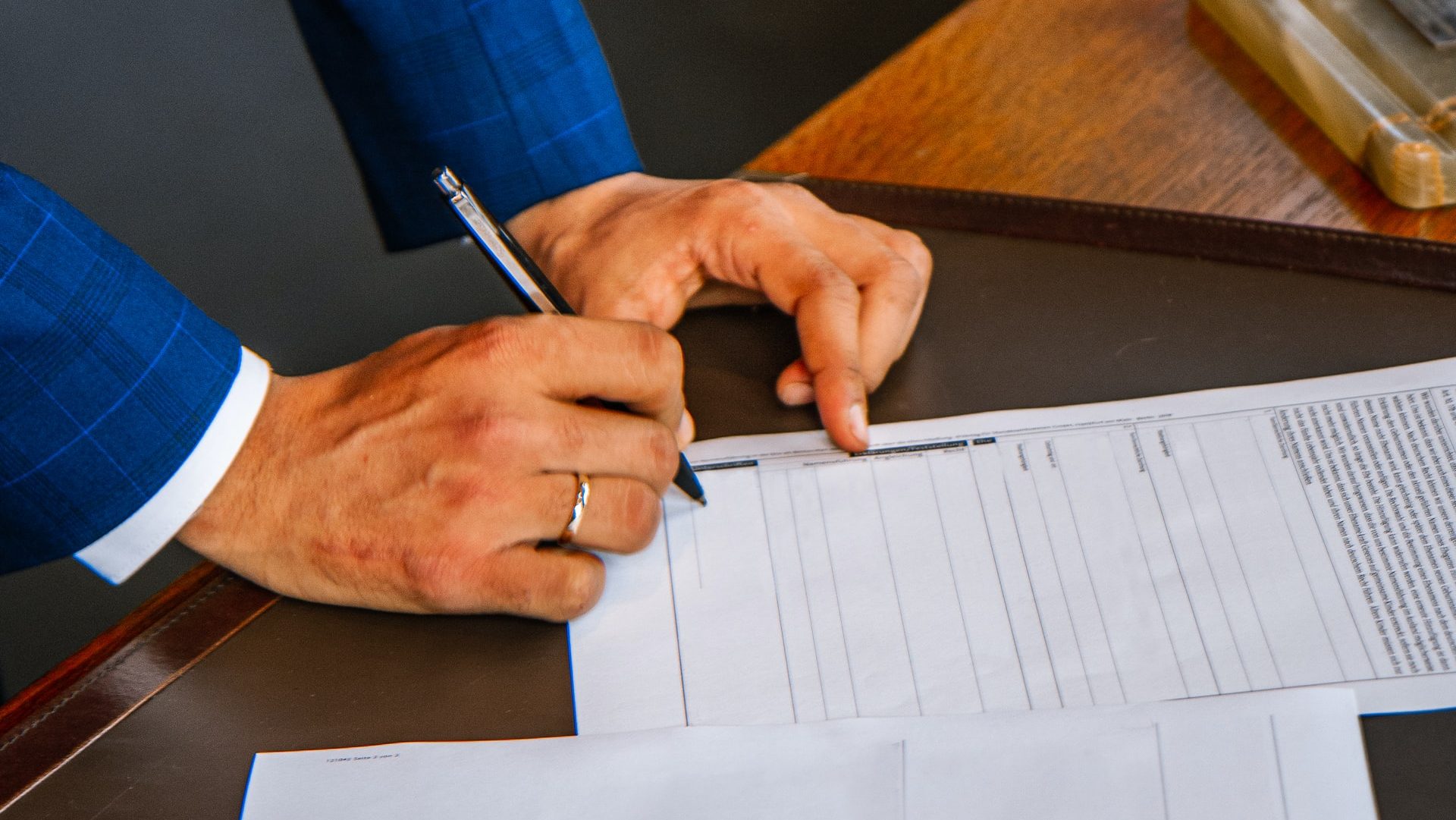 Foto de um homem assinando papeis, representando o fechamento de contrato com um Advogado Previdenciário